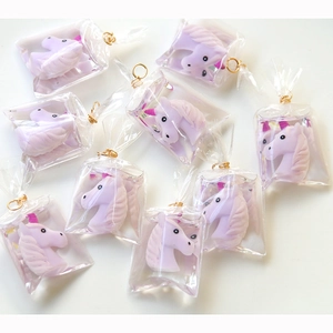 Detailed view of DIY resin unicorn charm pendants in miniature clear plastic bags