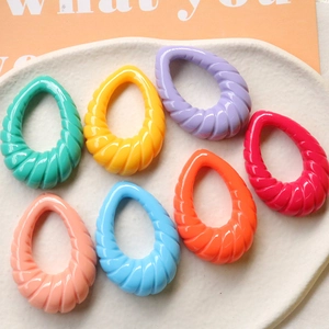 Dettaglio di ciondoli colorati a spirale in acrilico per creazione di orecchini
