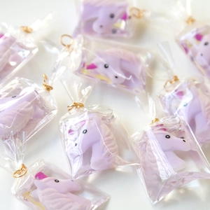 Detailed view of light purple resin unicorn charms with golden metal rings for DIY jewelry