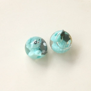Vue macro de perles en résine avec petit mouton bleu pour la création de bijoux DIY