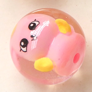 Vue macro d'une perle boule en résine transparente avec personnage rose pour bijoux