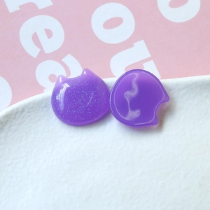 Detail of purple cat resin charms with glitter and glossy finish for DIY crafts