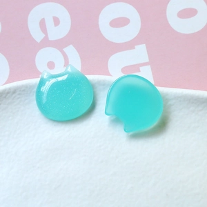 Macro view of light blue glittery resin cat-shaped flatback charms for DIY crafts