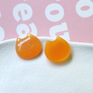 Close-up of orange glitter resin cat head charms for DIY hair accessories and earrings