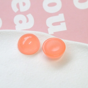 Vue macro de cabochons en résine 18mm rose orangé pailleté pour la création de bijoux DIY