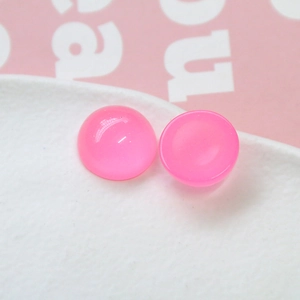 Gros plan de perles demi-sphères en résine rose de 18mm avec paillettes pour bijoux DIY