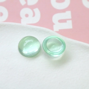 Vue macro de cabochons en résine pailletée vert clair 18mm avec dos plat pour DIY