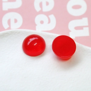 Vue macro de cabochons en résine rouge pailletée pour bijoux DIY et artisanat