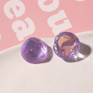 Detalle macro de dijes de resina púrpura con purpurina e iridiscentes para joyería DIY