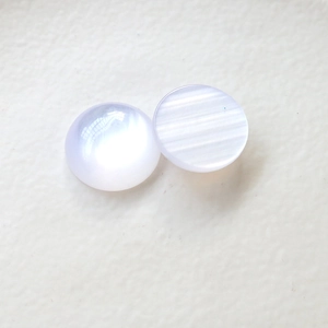 Dettaglio di cabochon in resina occhio di gatto aurora con riflessi perlati iridescenti