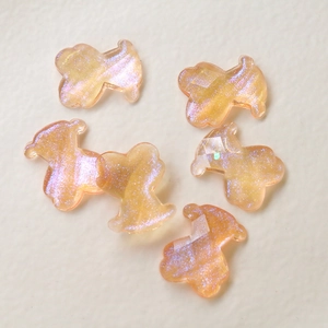 Detailansicht von sechs funkelnden Bären-Anhängern aus Harz für DIY-Schmuck in Orange