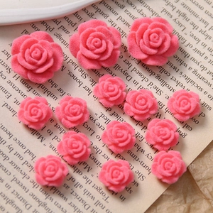 Macro shot of pink flocked acrylic rose charms for DIY jewelry on a book page