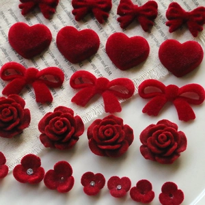 Detailed view of red flocked bow, heart, and rose acrylic charms with rhinestones