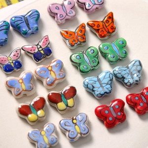 Vue macro de perles papillon en céramique peintes à la main pour création de bijoux