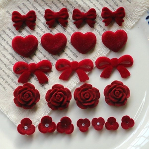 Macro shot of dark red velvet flocking DIY bow, heart and rose acrylic accessories
