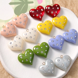 Flat lay of colorful resin heart charms with rhinestones for DIY jewelry making