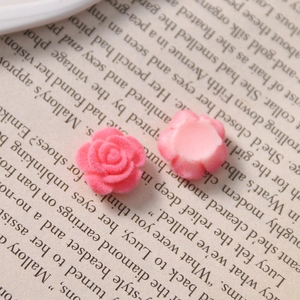 Macro detail of pink flocked rose and smooth flower charms for DIY jewelry making