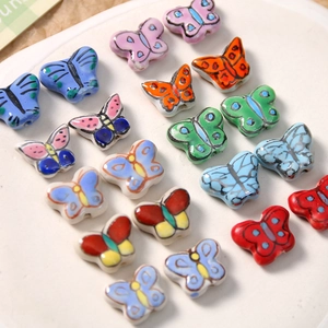 Gros plan de perles papillon en céramique peintes à la main pour création de bijoux
