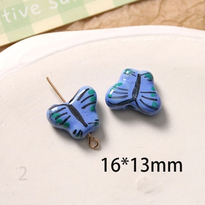 Vue détaillée des perles de papillon en céramique bleue peintes à la main pour bijoux