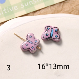 Détail macro de perles papillon en céramique rose 16x13mm avec motifs peints à la main DIY