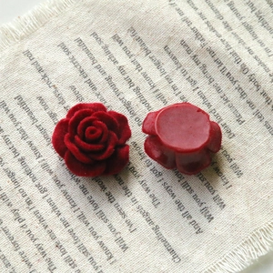 Macro detail of red flocked rose flower charms with velvet texture for DIY jewelry making