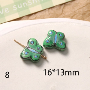 Vue macro d'une perle papillon en céramique peinte à la main 16x13mm pour bijoux DIY
