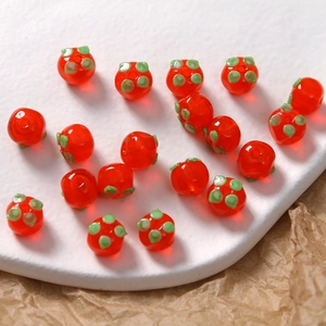 Makroaufnahme von Glasperlen in Kaki-Form mit grünen Blättern für DIY-Schmuck