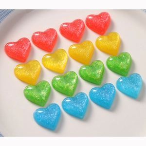 Macro shot of colorful heart-shaped resin charms with sparkling glitter for DIY crafts
