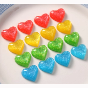 Glittery heart resin DIY accessories in colorful gradient tones on a white tray