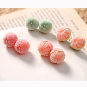 Detailed close-up of cute flocked fruit earrings showing peach and orange textures