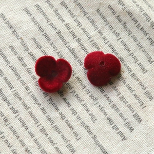 Close-up of red flocked flower-shaped acrylic DIY beads with velvet texture and holes