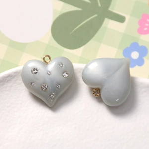 Detail of heart-shaped resin pendants with sparkling rhinestones and gold ring