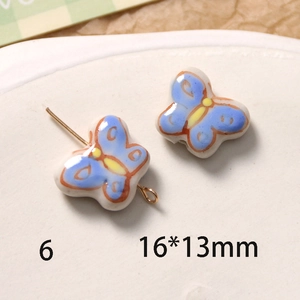 Gros plan d'une perle papillon en céramique bleu clair 16x13mm avec tige en métal doré