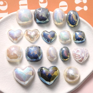 Corazones de resina nacarada y dijes geométricos con reflejos iridiscentes variados