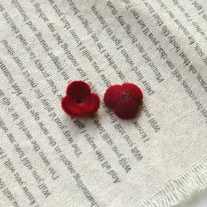 Close-up of red flocked flower DIY accessories with velvet texture on linen fabric