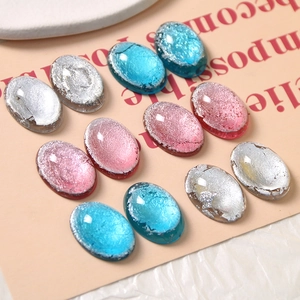 Dettaglio di cabochon ovali in resina con inserti in foglia d'argento rosa, blu e grigio