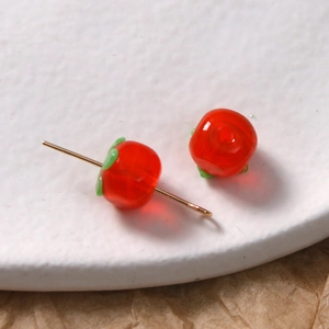 Makroansicht transluzenter roter Tomatenperlen mit grünen Blättern für DIY-Schmuck