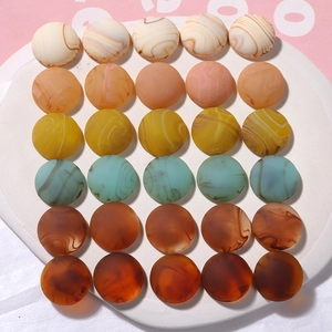 Macro shot of colorful ink-marble resin cabochons arranged on a white oval display plate