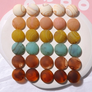 Flat lay of retro marble textured resin charms in earth tones on a white ceramic plate