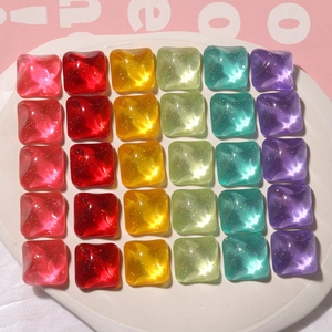 Macro shot of colorful resin square charms with water ripples and golden glitter detail