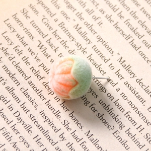 Close-up of cute flocked orange stud earrings on vintage book page background