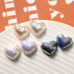 Primer plano de cuentas de resina en forma de corazón irisadas blancas y azules para bricolaje