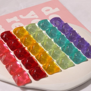 Macro detail of square candy-colored glitter resin patches for DIY craft accessories