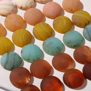 Macro detail of matte resin cabochons with ink smudge marble patterns and rich colors