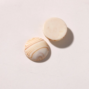 Detail view of round ink-style resin charms with matte finish and marble textures