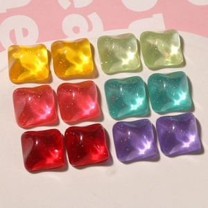 Close-up of square resin charms with glitter filling for DIY jewelry making