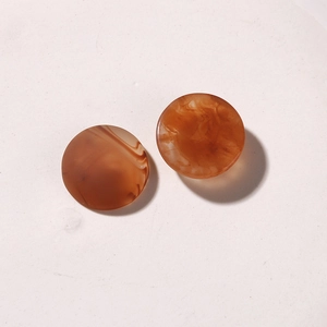 Close-up of vintage round resin charms with amber and caramel marble texture for DIY jewelry