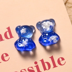 Macro shot of blue resin bear charms with cloudy texture and sparkling glitter finish