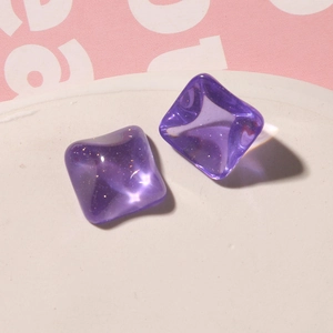 Close-up of square purple jelly resin studs with glitter inside on a white tray