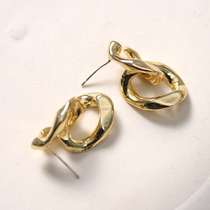 Minimalist vintage gold metal twist knot stud earrings for women on a white display stand